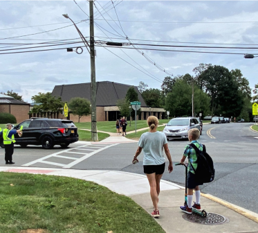 A photo of a woman and child crossing Hickory Ave. and Lee Street at the end of the school day